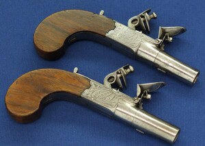 An Antique circa 1800-20 English pair of Box-Lock Flintlock pocket pistols with Thumbpiece safety catches by REYNOLDS LONDON. Caliber 12mm, length 16,5cm. In very good condition. Price 1.250 euro