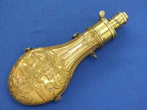 A fine antique 19th Century Embossed English Powder Flask, height 22 cm, on the charger 