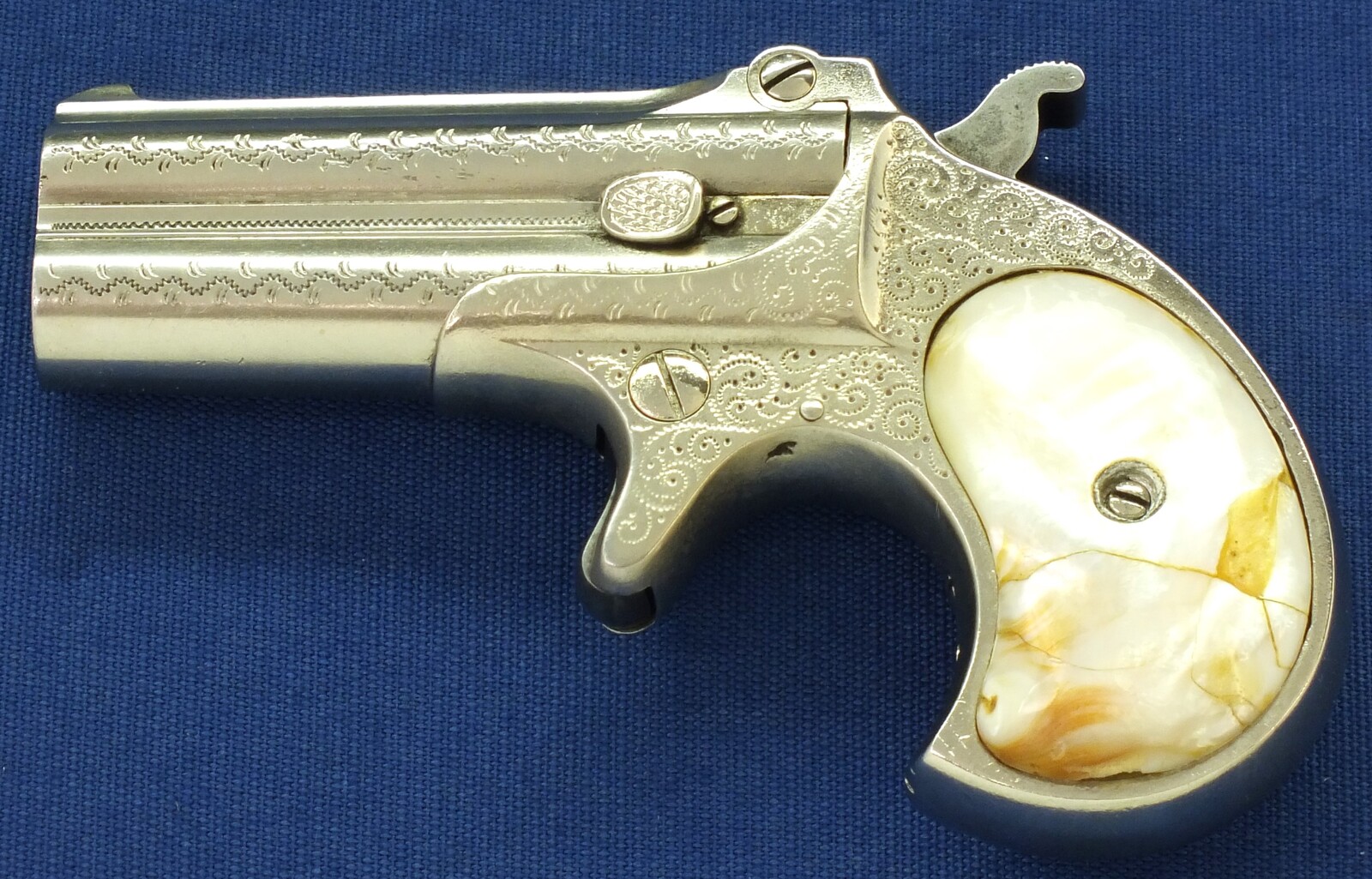 A fine antique American Nickel Plated factory Dot-Punch Engraved Remington Double Deringer Type I, Model No. 2 with Mother of pearl Grips. Caliber 41 Rimfire. In very good condition. Price 2.750 euro.