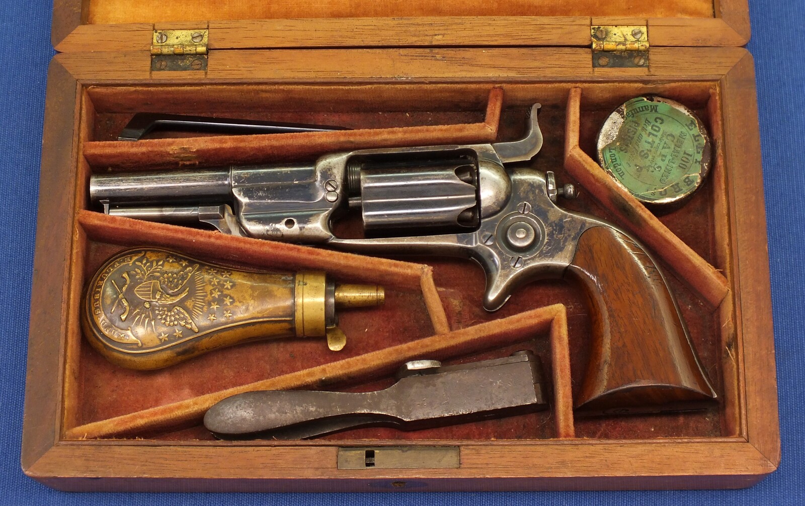 A fine antique Mahogany cased American Colt Model 1855 Root Model 5 Sidehammer Pocket Percussion Revolver. 5 shot Fluted Cylinder. 31 Caliber. 3,5 inch round barrel with New York address. In very good condition. Price 4.450 euro.