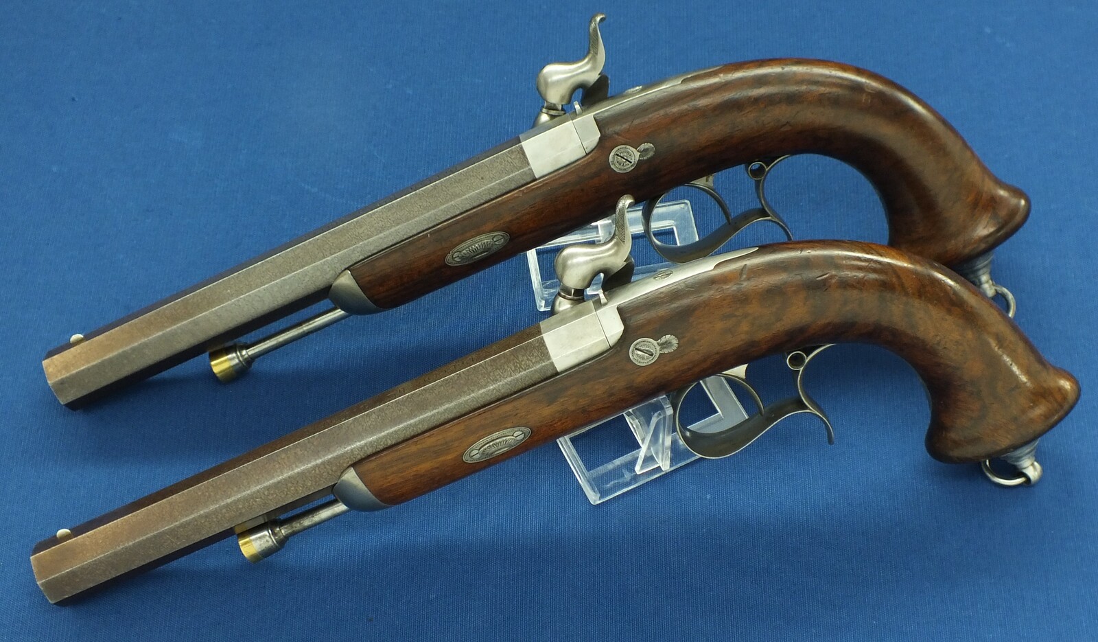 An antique 19th century circa 1860 pair of French Percussion pistols by Perrin Paris in vintage/antique Walnut veneered case with refitted and relined green interior. Caliber 17mm. Length 39cm. In very good condition. Price 2.750 euro.