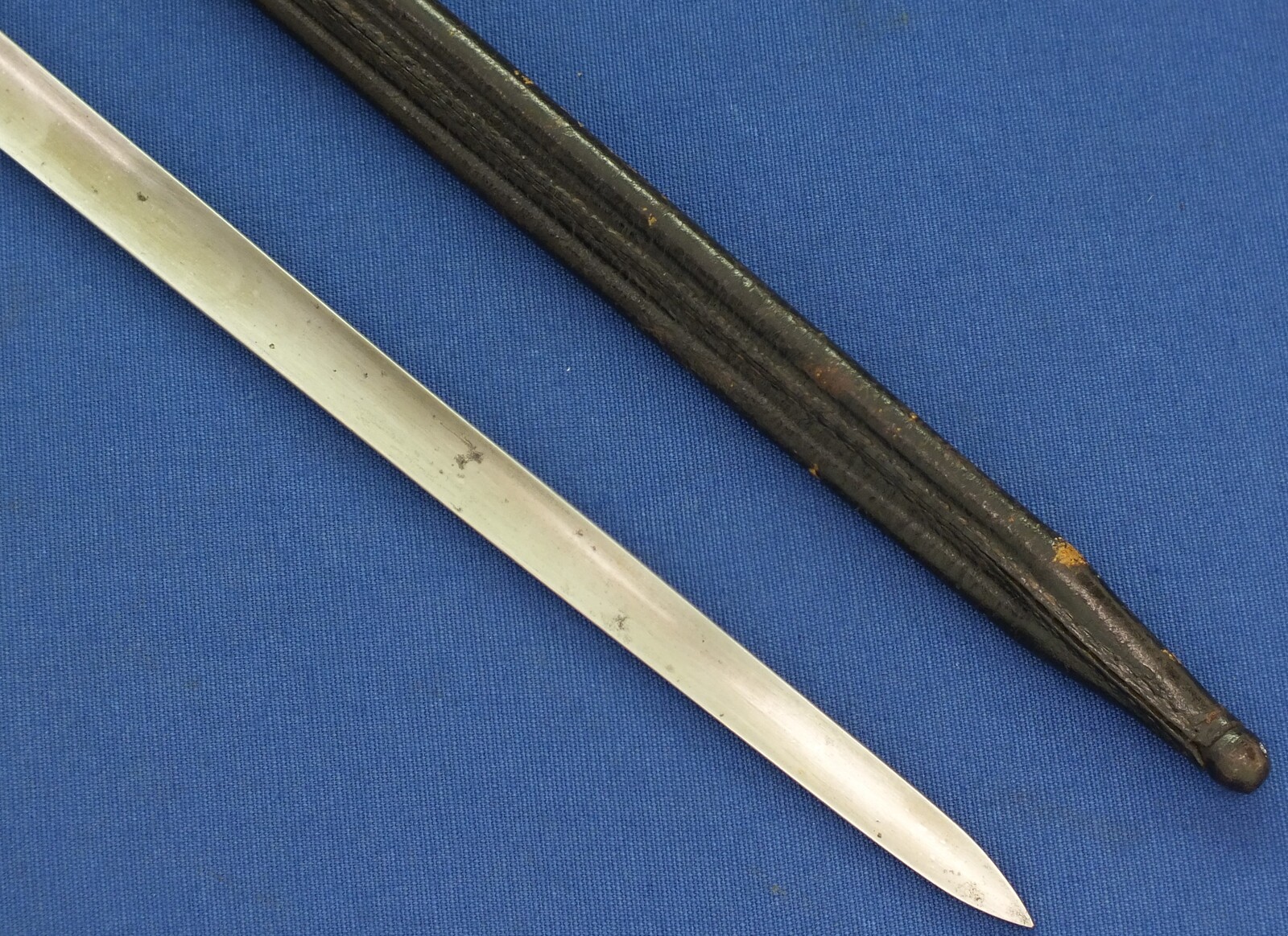 An antique Dutch Bayonet with leather scabbard Model 1815 for Flintlock, percussion and Snider Muskets. Made by J. Bar (Delft) Length 52cm. In very good condition