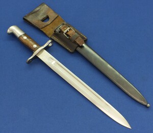 An antique Swiss Model 1889/11 Bayonet with metal scabbard and Leather frog made by Waffenfabrik Neuhausen. For Rifle's: Schmidt-Rubin Models 1896/11, 1911 Rifle and 1911 Carbine. SN423137. Length 44,5cm. In very good condition. Price 195 euro